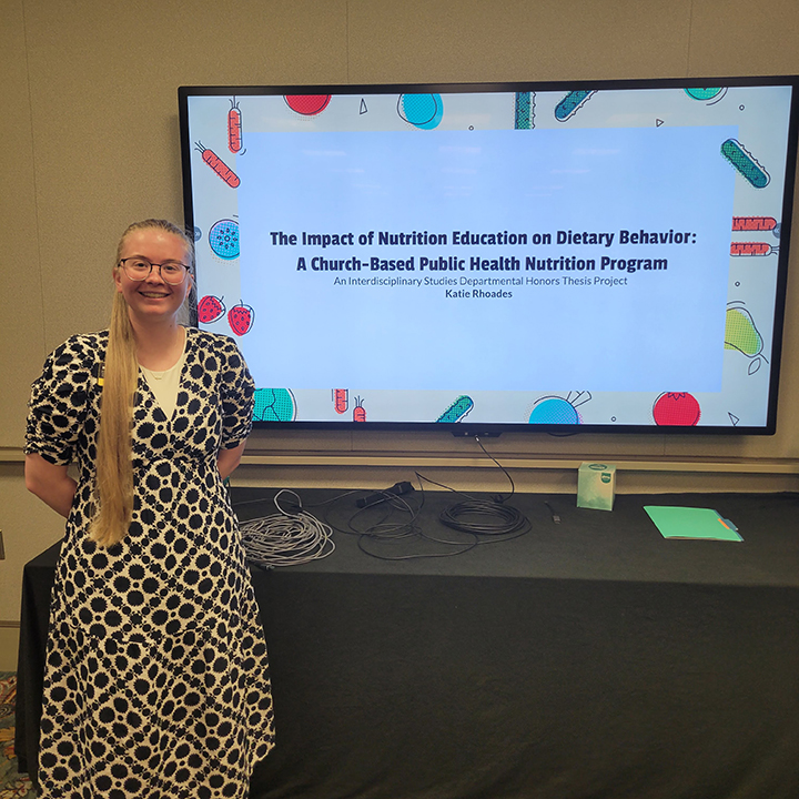 Photo of Katie Rhoades at SRHC with poster presentation