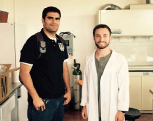 Here Alex (right) is shown in his lab coat with graduate student and lab mentor Oscar (left).