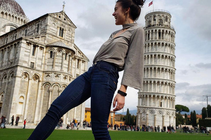 Kira Brisotti on a day trip in front of the Leaning Tower of Pisa.