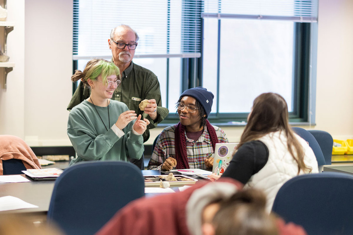 Professor showing minerals to students in classroom