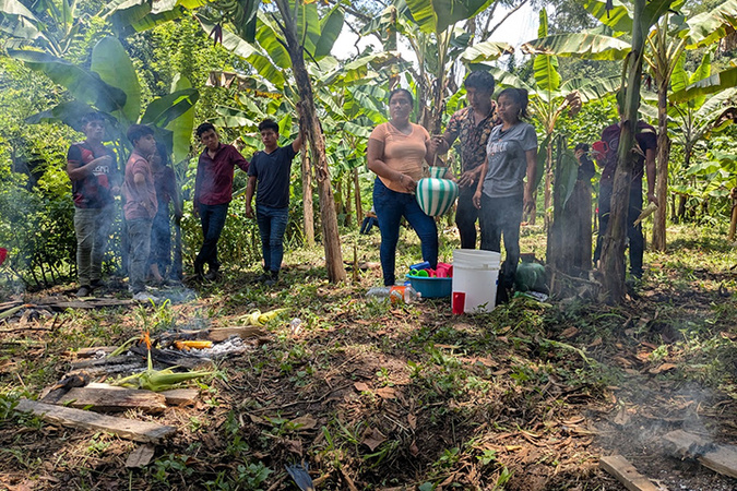 This image captures a moment in a community garden or agricultural setting in Latin America, likely a cooperative or indigenous farming initiative in Guatemala. 