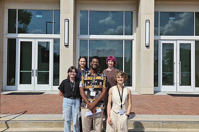 Group of five App State Honors College students in front of a building at UNC Pembroke attending North Carolina Honors Association conference.