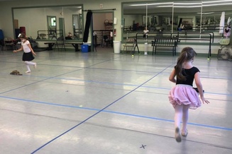dancers practice grand jetés in class. 