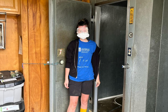 Senior Honors College student in a mask outside a walk-in refrigerator. Sierra Focazio participates in an Alternative Service Experience with The Elephant Sanctuary in Tennessee.