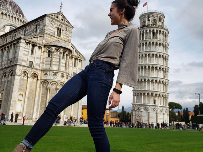 Kira Brisotti on a day trip in front of the Leaning Tower of Pisa.